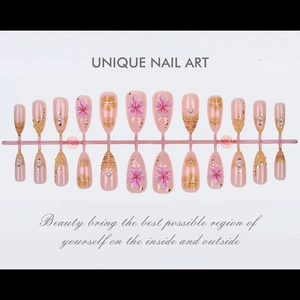 Detail of 24pcs pink almond fake nails with 3D floral accents and pearl decorations