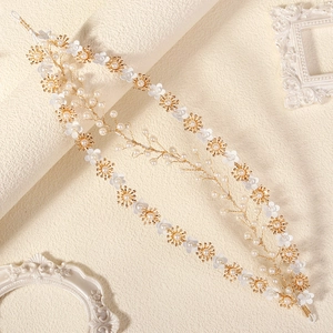 Detail of bridal hair vine with white flowers, pearls, and gold wire on vintage frames