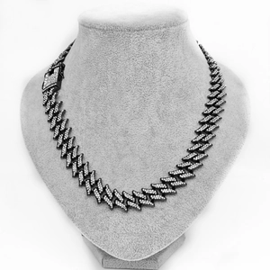 16mm wide black gold Cuban chain with iced-out crystals on a grey velvet bust display
