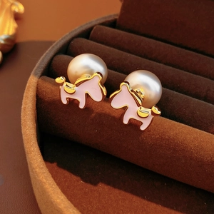 Macro detail of 18K gold plated horse pearl earrings in a velvet jewelry box