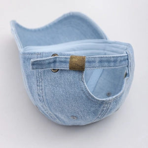Nahaufnahme der hellblauen verwaschenen Jeans-Kappe mit verstellbarer Bronzemetallschnalle