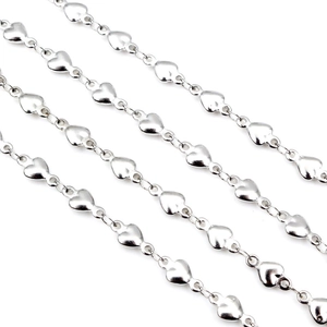Macro shot of silver heart-shaped chain links with S925 hallmark and polished finish
