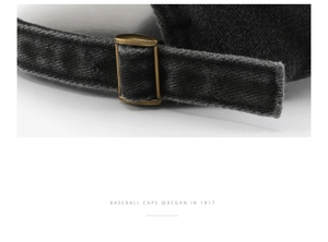 Close-up of adjustable bronze metal buckle and washed black cotton on baseball cap