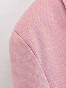 Close-up of pink blazer showing detailed textured fabric and shoulder stitching details