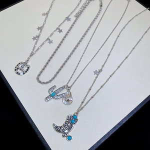 Detailed view of western style necklaces featuring turquoise boots and star charms