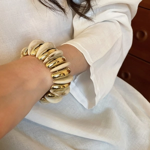 Close-up of model wearing chunky acrylic marble and gold metal elastic stretch bracelet