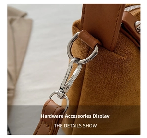 Détail rapproché de l'anneau en D argenté sur le sac oreiller en daim marron chic