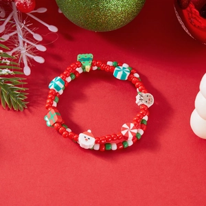 Detailed view of Christmas beaded bracelet with festive charms on a red holiday background