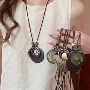 Vintage wooden leaf pendant necklace with bronze charms on a long leather cord for women