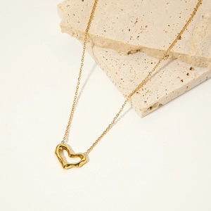 Irregular hollow heart pendant necklace in 18k gold plated stainless steel on beige stones