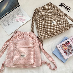 Flat lay of quilted heart pattern plaid backpacks with drawstring and front pockets