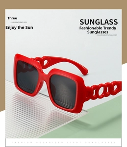 Detailed view of red square sunglasses featuring unique hollow thick chain temple design