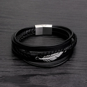 Detail of black multi-layer braided leather bracelet with silver feather and magnetic clasp