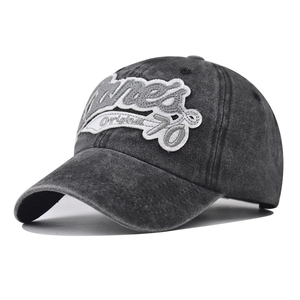 Detail view of washed cotton baseball cap with vintage distressed texture and 3D embroidery