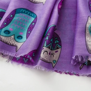 Detailed texture of cotton linen scarf featuring purple owl pattern and frayed edges