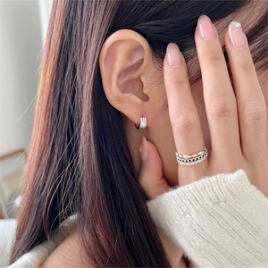 Close-up of minimalist S925 silver striped hoop earrings and stacked rings set