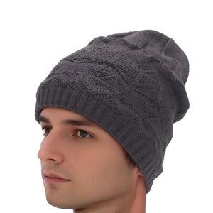 Detail view of dark grey knitted beanie featuring textured diamond pattern and ribbed edge