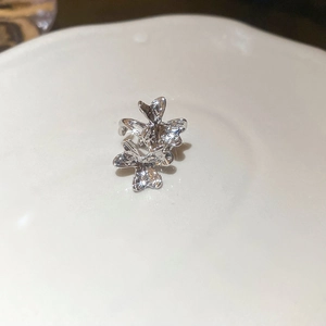 Macro shot of silver butterfly earring with shimmering zircon butterfly pendant detail
