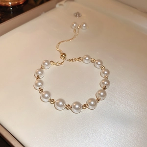 Detail of adjustable French vintage pearl bracelet with gold beads on silk