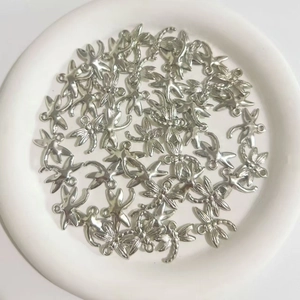 Macro shot of silver plated dragonfly charms for DIY jewelry making in a white bowl