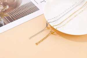 Close-up of minimalist gold and silver heart necklaces with lobster clasp and extender