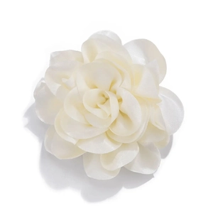 Detailed macro view of white silk camellia flower pin with multi-layer fabric petals