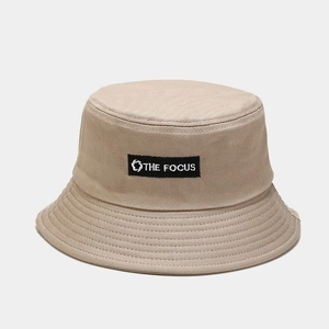 Detail of THE FOCUS woven label and parallel stitching on khaki cotton bucket hat