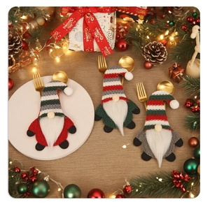 Three-piece Christmas gnome cutlery holders in red, green, and grey on a festive table