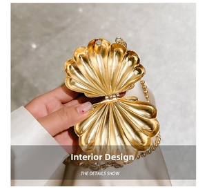 Detailed interior of a gold shell-shaped mini bag with a beaded chain handle