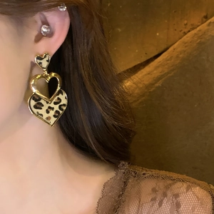 Boucles d'oreilles cœur rétro avec imprimé léopard et cadres en métal doré sur modèle