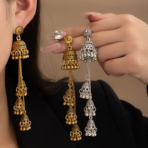 Close-up of bohemian tassel earrings featuring vintage bells and intricate floral details