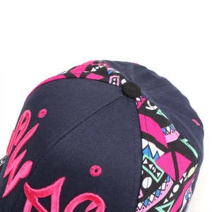 Detail of pink graffiti letter embroidery and colorful geometric patchwork on a baseball cap