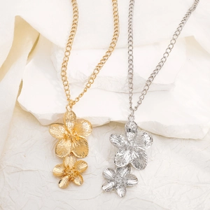 Close-up of dual-layer flower necklaces in gold and silver finish with metallic texture