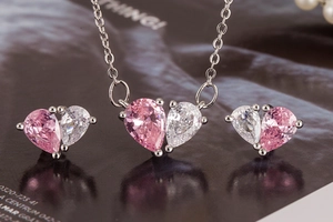 Macro detail of heart-shaped necklace and earrings with pink and white zirconia stones