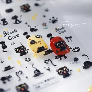Detail of cartoon black cat nail stickers featuring paw prints and yellow star patterns