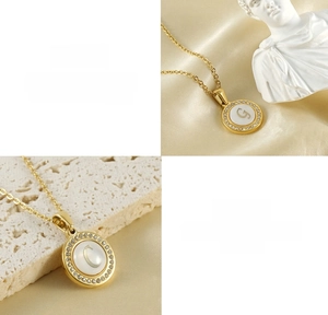 Vue détaillée du collier en acier titane doré avec incrustation de nacre et pendentif lettre