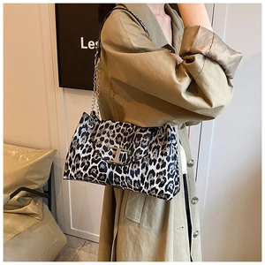 Detail of leopard print crescent bag with golden T-shaped lock and chain strap