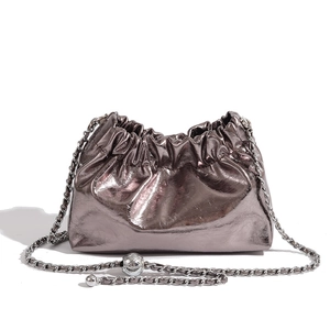 Detail of metallic pleated cloud bag with stylish chain strap and sphere charm decoration