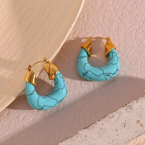 Detailed macro view of gold-plated hoop earrings featuring marbled turquoise U-shaped pendants