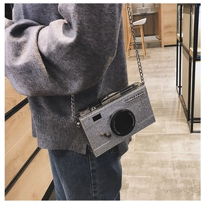 Detail of silver glitter camera bag with chain strap and Steal the Spotlight lens text