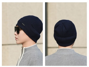 Detail of navy blue ribbed knit beanie with silver metal logo and side profile view