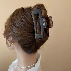 Close-up of a large leopard print tortoiseshell hair claw clip used in a bun hairstyle