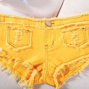 Dettaglio di pantaloncini di jeans giallo acceso con bordi sfrangiati e bottone in metallo