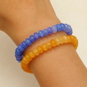 Gros plan de bracelets en perles de cristal bleu et orange aux textures de pierre