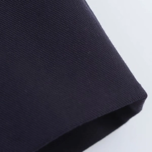 Macro close-up showing high-quality twill texture of dark blue luxury dress fabric