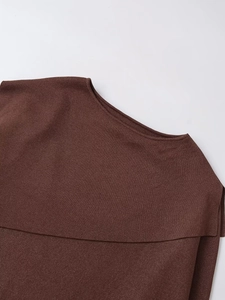 Macro shot of dark brown knit poncho neckline showing high-quality metallic thread texture