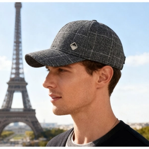 Dettaglio del berretto in lana a quadri grigi con placca metallica e sfondo Torre Eiffel