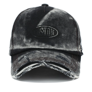 Detail of distressed brim and embroidered patch on acid wash denim baseball cap