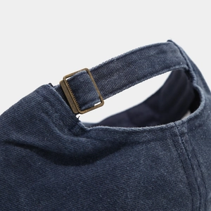 Detail of navy cotton baseball cap with vintage bronze metal buckle adjustment