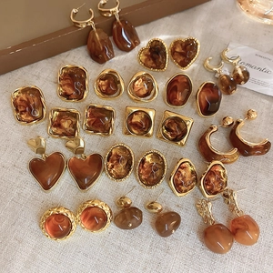 Detailed collection of amber resin earrings with gold metal frames in geometric shapes